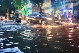 Đường Tô Ngọc Vân-Quận Thủ Đức ngập 1/2 bánh xe khiến người dân di chuyển khó khăn. (Ảnh: Hồng Giang/TTXVN.)