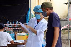 Nhân viên y tế hướng dẫn lái xe khai báo y tế tại chốt kiểm soát dịch bệnh Thừa Thiên-Huế. (Ảnh: Đỗ Trưởng/TTXVN)