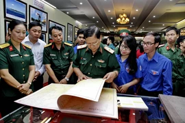 Cán bộ chiến sỹ Bộ Tư lệnh Quân Khu 7 và thanh niên thành phố tham quan triển lãm. (Ảnh: Thế Anh/TTXVN)