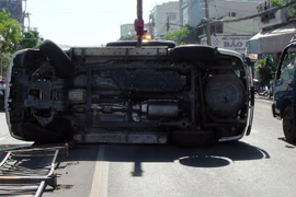 Chiếc xe 7 chỗ lật nhào trên cầu Vĩnh Tuy. (Ảnh: Văn Cảnh/Vietnam+)