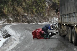 Đường trơn khiến nhiều phương tiện lưu thông gặp khó khăn. (Ảnh: Nguyễn Duy/TTXVN)