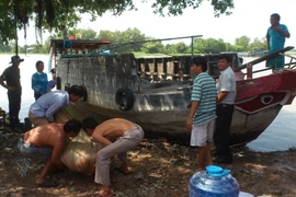 Thi thể nạn nhân sau khi trục vớt được đưa đi khám nghệm tử thi. (Ảnh: Thanh Tân/TTXVN)