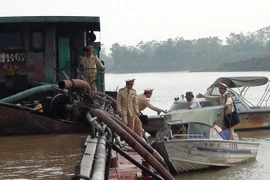 Lực lượng Cảnh sát giao thông đường thủy - Công an tỉnh Bắc Ninh bắt giữ tàu BKS HD0612 khai thác cát sỏi trái phép trên sông Đuống. (Ảnh: Thái Hùng/TTXVN)