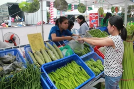 Người dân mua sắm tại phiên chợ nông sản an toàn. (Ảnh: Dương Chí Tưởng/TTXVN)
