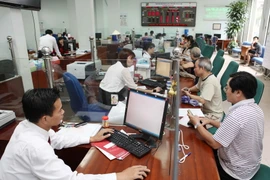 Khách hàng giao dịch tại Agribank Chi nhánh Đông Hà Nội. (Ảnh: Trần Việt/TTXVN)