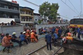 Nhân viên cứu hộ tại hiện trường vụ tai nạn. (Ảnh: AFP/TTXVN)