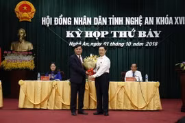 Ông Nguyễn Xuân Sơn - Phó Bí thư Thường trực Tỉnh ủy, Chủ tịch Hội đồng Nhân dân tỉnh tặng hoa chúc mừng ông Thái Thanh Quý. (Ảnh: Bích Huệ/TTXVN)