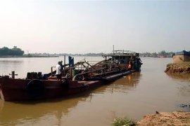 Chiếc tàu khai thác cát trái phép bị lực lượng chức năng bắt giữ. (Ảnh: TTXVN phát)