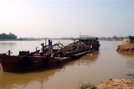Chiếc tàu khai thác cát trái phép bị lực lượng chức năng bắt giữ. (Ảnh: TTXVN phát)