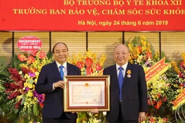 Thủ tướng Nguyễn Xuân Phúc trao Huân chương Độc lập hạng Nhất tặng Trưởng ban Bảo vệ, chăm sóc sức khỏe cán bộ Trung ương Nguyễn Quốc Triệu. (Ảnh: Lâm Khánh/TTXVN)