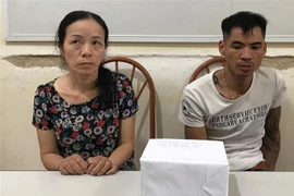 Đối tượng Nguyễn Thị Yến và Nguyễn Hữu Chuyên, cùng tang vật tại cơ quan Công an. (Ảnh: TTXVN phát)