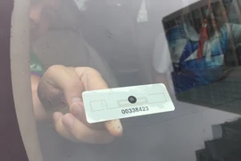Dán thẻ thu phí tự động lên xe ôtô. (Ảnh: Việt Hùng/Vietnam+)