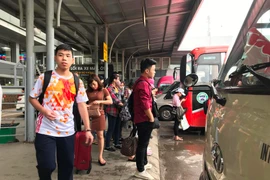 Hành khách chờ xe để về quê. (Ảnh: Việt Hùng/Vienam+)