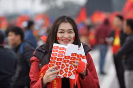 Cổ động viên nữ với băng rôn dán trên mặt sẽ tiếp lửa cho đội tuyển Việt Nam trong trận chung kết AFF Cup. (Ảnh: Minh Sơn/Vietnam+)