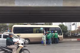 Mỗi khi khách xuống, tài xế xe ôm truyền thống hay sử dụng công nghệ Grab đều vội vã đến để chào mời đi xe. (Ảnh: Phương Linh/Vietnam+)