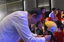 Phó Thủ tướng Chính phủ Trương Hòa Bình trao tặng mũ bảo hiểm cho học sinh lớp Một. (Ảnh: Việt Hùng/Vietnam+)