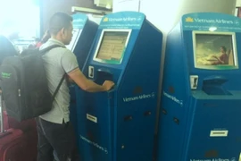 Hành khách đang làm thủ tục check-in tại kios của Vietnam Airlines. (Ảnh: Việt Hùng/Vietnam+)