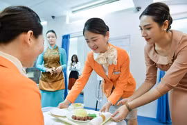 Các sinh viên Hàn Quốc thực hành kỹ năng phục vụ món ăn trên mô hình khoang máy bay.