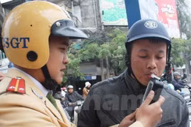 Cảnh sát giao thông tiến hành đo nồng độ cồn của người điều khiển phương tiện. (Ảnh: Việt Hùng/Vietnam+)
