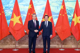 Phó Thủ tướng Trần Lưu Quang với Bộ trưởng Bộ Ngoại giao Trung Quốc Vương Nghị. (Ảnh: Phạm Kiên/TTXVN)