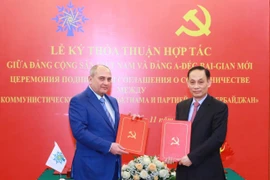 Trưởng Ban Đối ngoại Trung ương Lê Hoài Trung và Phó Chủ tịch Đảng Azerbaijan Mới Tahir Budagov trao bản thoả thuận hợp tác giữa hai Đảng. (Ảnh: Phương Hoa/TTXVN)