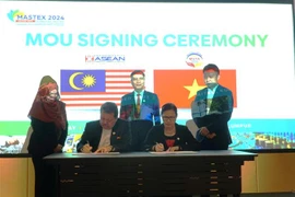 Chủ tịch Hội hữu nghị Malaysia-Việt Nam, Trần Thị Chang (bên trái) ký MoU với Chủ tịch ACCI. (Ảnh: Hằng Linh/TTXVN)