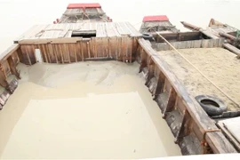 Các thuyền chứa đầy cát vừa được bơm hút trái phép từ sông Đồng Nai. (Ảnh: Công Phong/TTXVN)