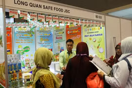 Khách hàng đang tìm hiểu những sản phẩm của công ty Long Quân Save Food Việt Nam. (Ảnh: Hải Ngọc/Vietnam+)