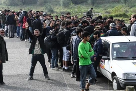 Người di cư xếp hàng nhận lương thực cứu trợ tại Grande-Scynthe, gần Calais, miền bắc Pháp ngày 27/9/2017. (Nguồn: AFP/TTXVN)