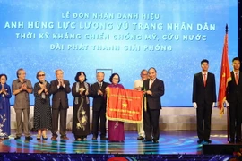 Thủ tướng Nguyễn Xuân Phúc trao tặng danh hiệu Anh hùng Lực lượng vũ trang nhân dân thời kỳ kháng chiến chống Mỹ, cứu nước của Chủ tịch nước cho Đài Phát thanh Giải phóng. (Ảnh: Thống Nhất/TTXVN)