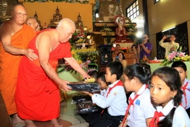 Các nhà sư trao quà cho các học sinh nghèo vượt khó tại chùa Bàng Long ở thủ đô Vientiane, Lào. (Ảnh: Phạm Kiên/TTXVN)