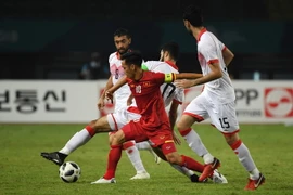 Cầu thủ Nguyễn Văn Quyết (số 10) của Olympic Việt Nam tranh bóng quyết liệt với các cầu thủ Olympic Bahrain tại vòng 1/8 ASIAD 2018 diễn ra ở Bekasi, Indonesia ngày 23/8. (Ảnh: AFP/TTXVN)
