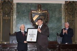 Hiệu trưởng trường Đại học Tổng hợp La Habana trao bằng Tiến sỹ Danh dự khoa học Chính trị và Quyết định cho Tổng Bí thư Nguyễn Phú Trọng. (Ảnh: Trí Dũng/TTXVN)