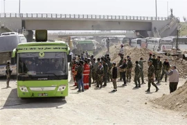 Phiến quân Syria sơ tán khỏi khu vực do Chính phủ kiểm soát ở Đông Ghouta, ngoại ô Damascus, Syria ngày 25/3/2018. (Ảnh: AFP/TTXVN)