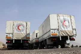 Đoàn xe tải chuyển hàng cứu trợ đậu tại trạm kiểm soát Wafideen, ngoại ô Đông Ghouta ngày 8/3. (Nguồn: AFP/TTXVN)