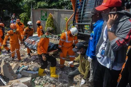 Lực lượng cứu hộ chuyển thi thể nạn nhân ra khỏi đống đổ nát của một khách sạn bị sập sau thảm họa động đất và sóng thần ở tỉnh Trung Sulawesi, Indonesia ngày 1/10/2018. (Ảnh: THX/TTXVN)