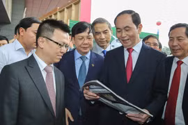 Chủ tịch nước Trần Đại Quang xem một ấn phẩm của TTXVN. (Ảnh: Lê Minh Sơn/Vietnam+)