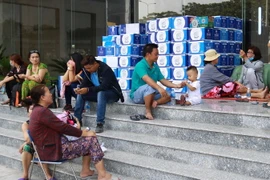 Người dân đang sinh hoạt tạm cư tại tòa nhà City Gate. (Ảnh: Thanh Vũ/TTXVN)