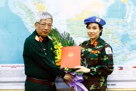 Thượng tướng Nguyễn Chí Vịnh, Ủy viên Trung ương Đảng, Ủy viên Thường vụ Quân ủy Trung ương, Thứ trưởng Bộ Quốc phòng trao Quyết định của Chủ tịch nước cho Thiếu tá Đỗ Thị Hằng Nga, Trợ lý Phòng Tham mưu - Kế hoạch thuộc Trung tâm Gìn giữ hòa bình Việt Na