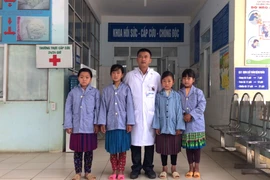 Trưởng khoa Hồi sức-Cấp cứu-Chống độc, Bệnh viện Đa khoa huyện Mèo Vạc chụp ảnh với 4 cháu học sinh sáng 13/4 trước khi 3 cháu được xuất viện. (Ảnh: Minh Tâm/TTXVN)