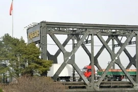 Xe chở hàng hóa di chuyển trên cây cầu hữu nghị Trung Quốc - Triều Tiên nhìn từ Đan Đông, Trung Quốc ngày 28/3. (Nguồn: Kyodo/TTXVN)