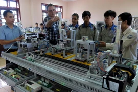 Chuyên gia Pháp hướng dẫn học sinh thực hành môn điện công nghiệp. (Ảnh: Vĩnh Trọng/TTXVN)