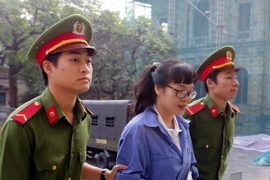 Dẫn giải bị cáo Huỳnh Thị Huyền Như đến phiên tòa 8/2. (Ảnh: Hoàng Hải/TTXVN)