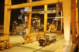  Cần trục giàn QC xếp dỡ hàng container tại Cảng Tân Vũ. (Ảnh: Minh Huệ/TTXVN) 