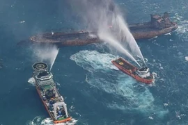 Tàu phòng vệ của Nhật Bản và tàu tuần tra Trung Quốc nỗ lực dập lửa cháy trên tàu Sanchi. (Nguồn: CNN/TTXVN)