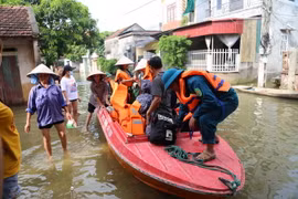 Người dân xóm Bến Vôi, thôn Cấn Hạ, xã Cấn Hữu được di chuyển bằng cano trong khi chờ nước rút. (Ảnh Mạnh Khánh/TTXVN)