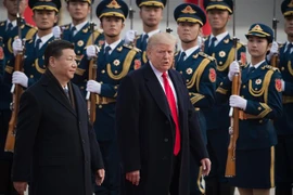 Chủ tịch Trung Quốc Tập Cận Bình (trái) và Tổng thống Mỹ Donald Trump duyệt đội danh dự tại lễ đón ở Bắc Kinh, Trung Quốc ngày 9/11/2017. (Ảnh: AFP/TTXVN)