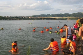Việc người dân kéo nhau ra sông Đà tắm, bơi lội khá nguy hiểm. (Ảnh: Thanh Hải/TTXVN)
