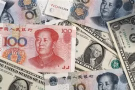 Đồng nhân dân tệ của Trung Quốc và đồng đôla Mỹ. (Ảnh: Kyodo/TTXVN)