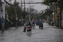 Khu vực đường Lê Văn Lương, huyện Nhà Bè bị ngập sâu do triều cường. (Ảnh: Xuân Dự/TTXVN)